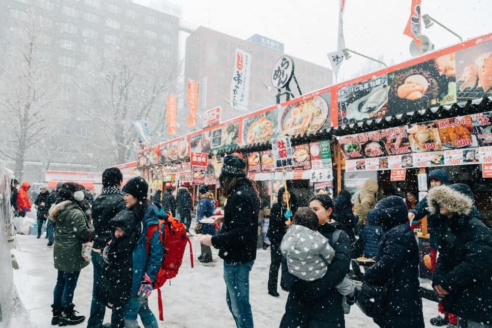 people and food stalls in Sapporo in the snow