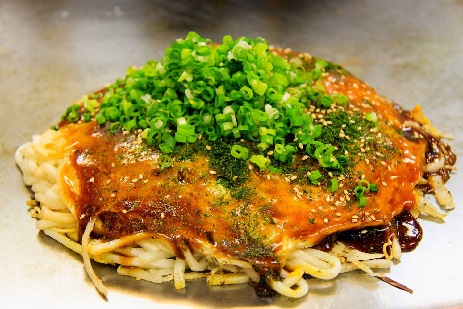 Okonomiyaki with spring onions on top