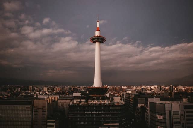 A picture of Kyoto tower standing tall above the city of Kyoto