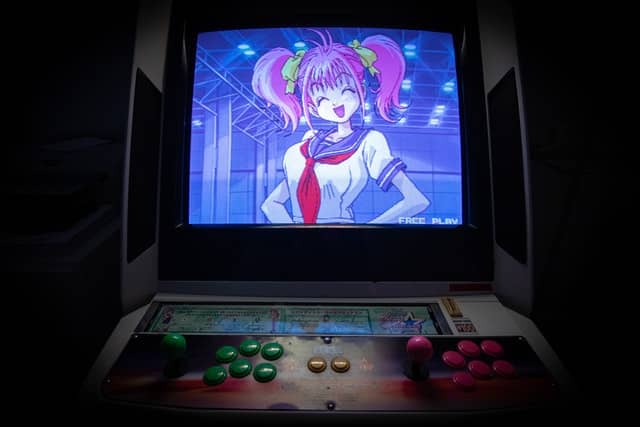 A Japanese arcade game with an anime character on the screen.