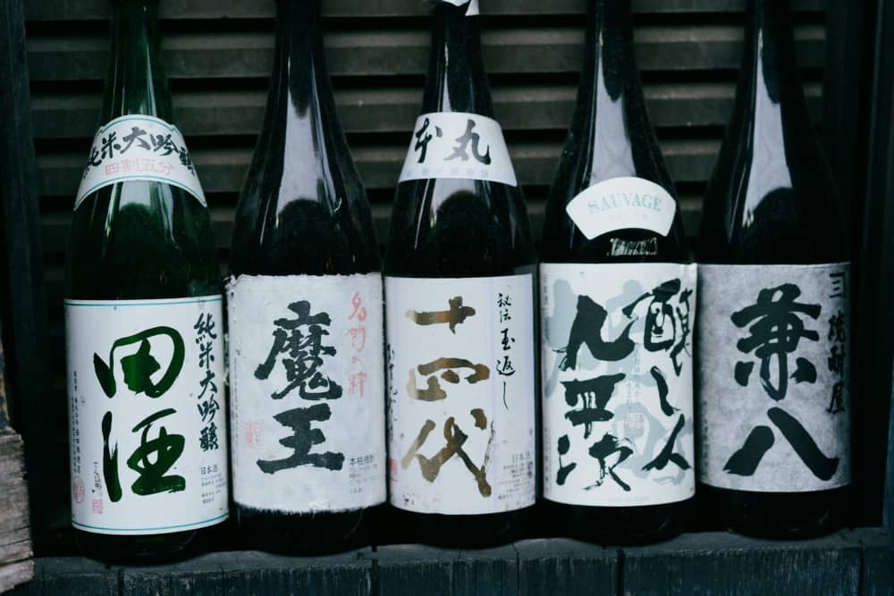 a close up of five sake bottles