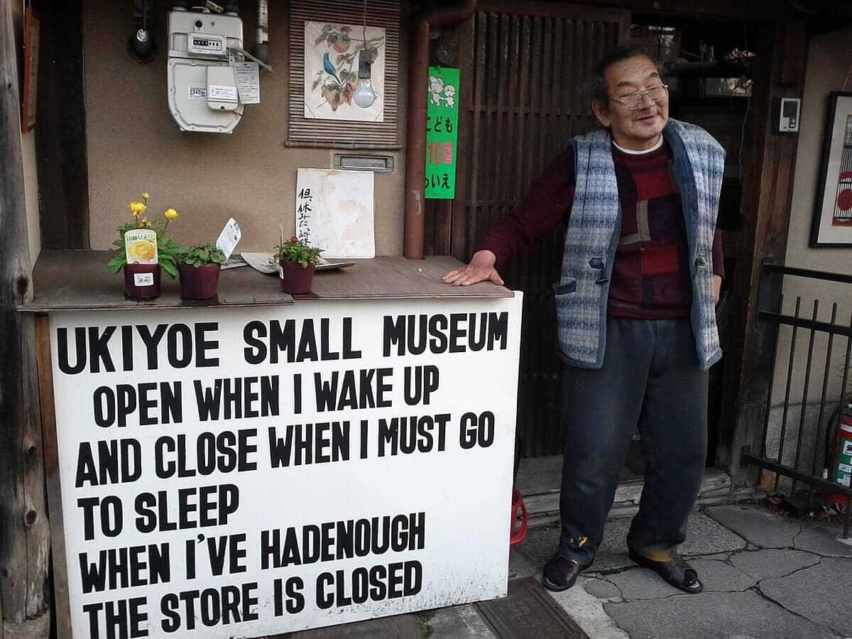 Ichimura Mamoru, owner of the Ukiyoe Small Museum shop standing outside his shop.