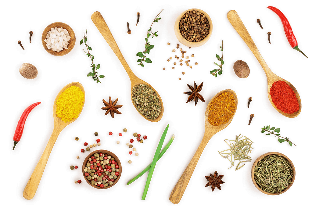 mix of spices in wooden spoon isolated on a white background