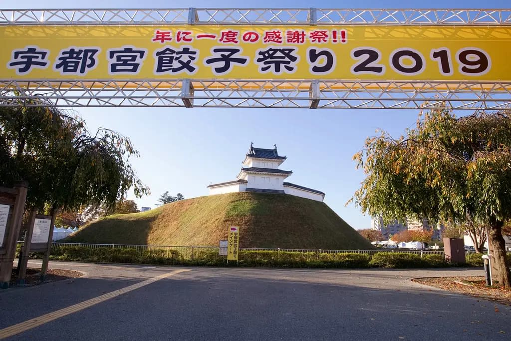 A traditional Japanese shrine, on top of a small grassy hill in Utsunomiya City, Togichi Prefecture.