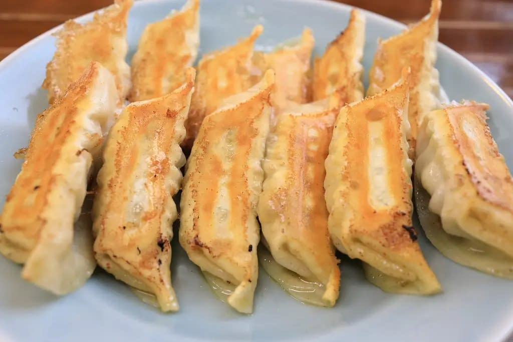 A number of fried dumplings, presented on a plate.