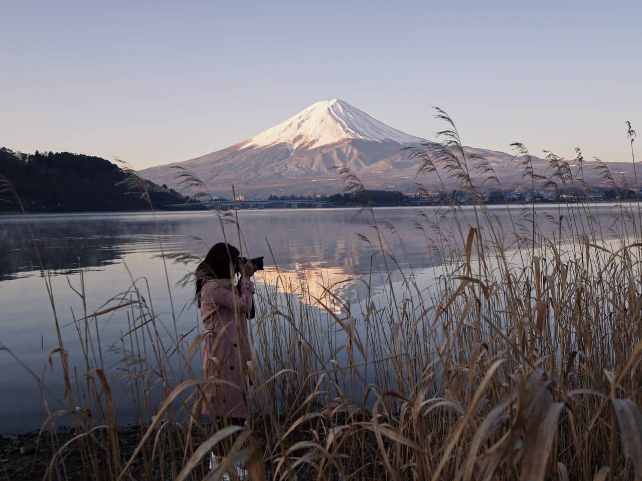 Woman taking photos of mountains in Japan
