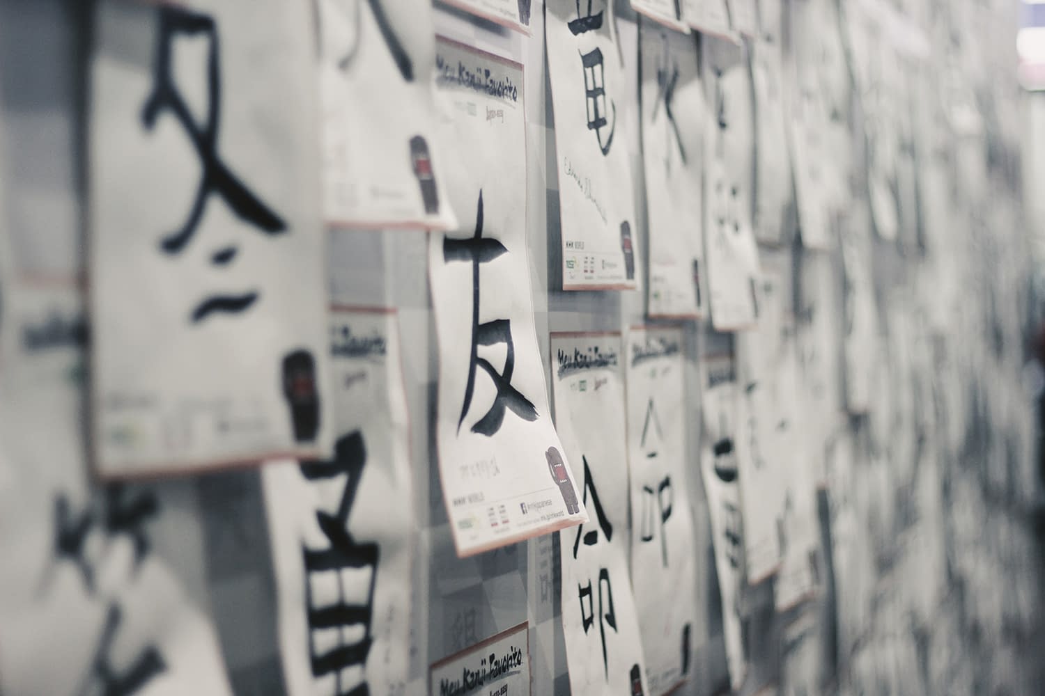 Japanese calligraphy on sheets of paper on a wall