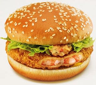 Patty made from shrimps, covered in batter on a burger bun with lettuce and hot sauce.