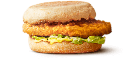 A crispy chicken piece sandwiched between two muffin buns and a spread of avocado.