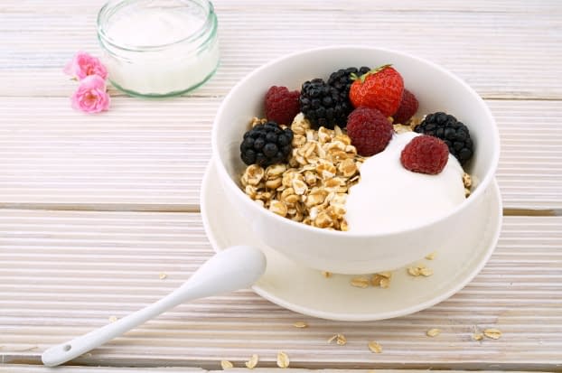 a bowl of yogurt with berries and granola in it