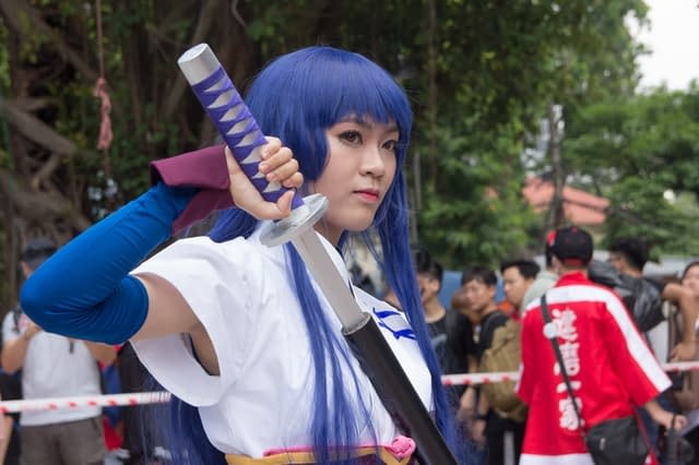 A woman cosplaying holding a sword