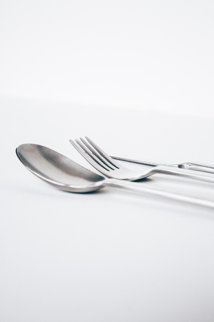 a spoon, a fork, and a knife against a white background