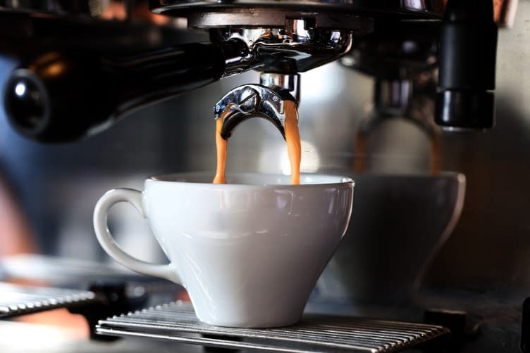 a coffee machine pouring coffee into a cup