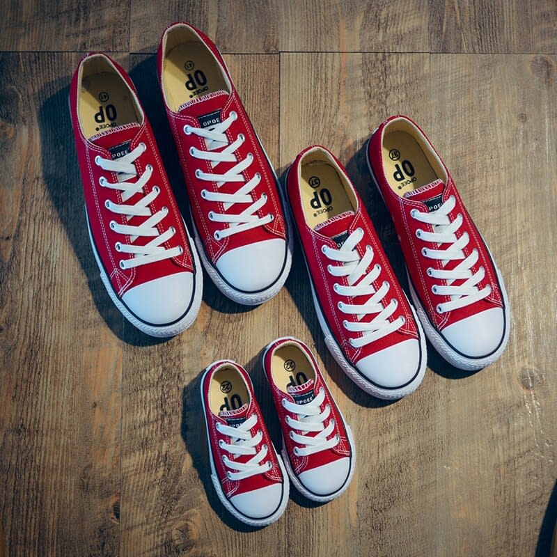Three pairs of red trainers, ranging from large to small