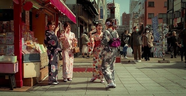 Japanese friends laughing together outside a shop.