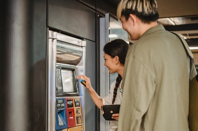 A young couple buying train tickets from a ticket machine