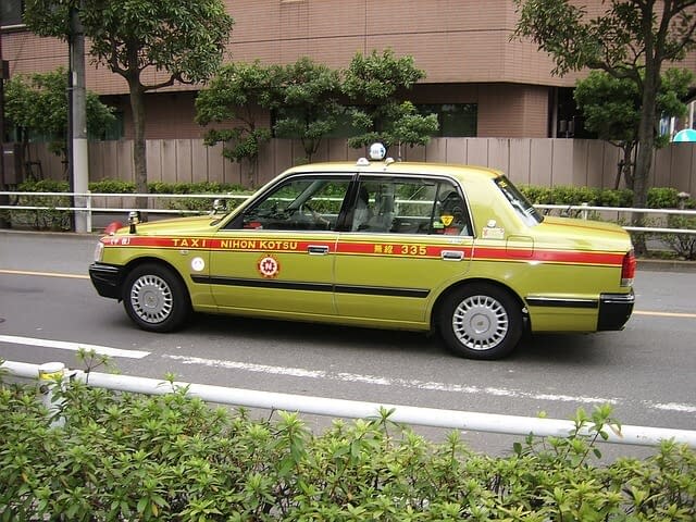 A Japanese taxi driving along the road.