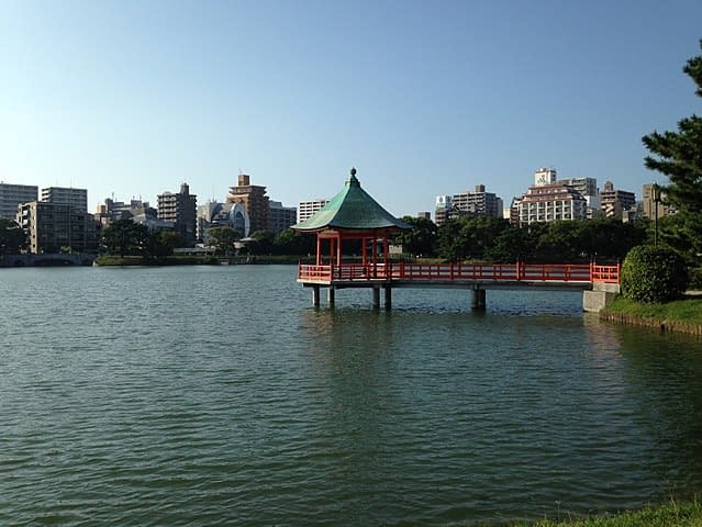 a lake in Fukuoka with buildings in the background