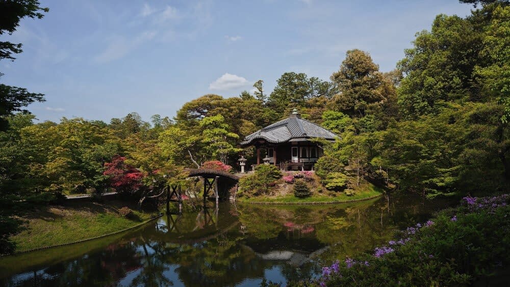 Katsura Imperial Villa surrounded by tree, flowers and a pond.