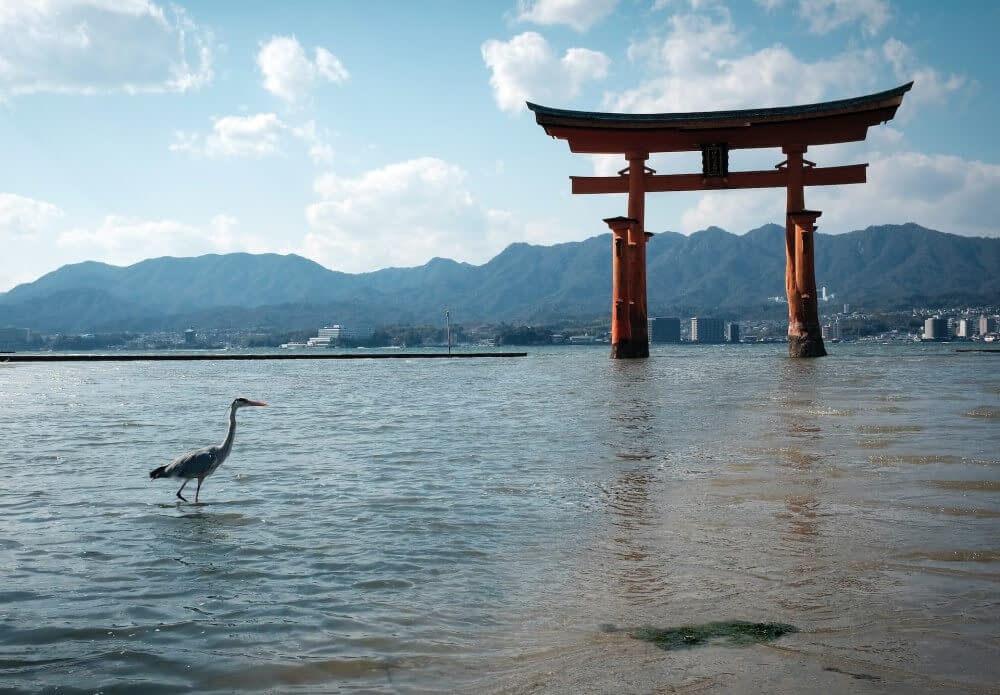 torii gate surrounded by water and mountains