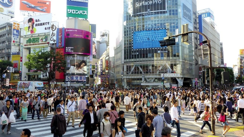 An image of Shibuya Crossing in Tokyo with hundreds of people using the crossroads