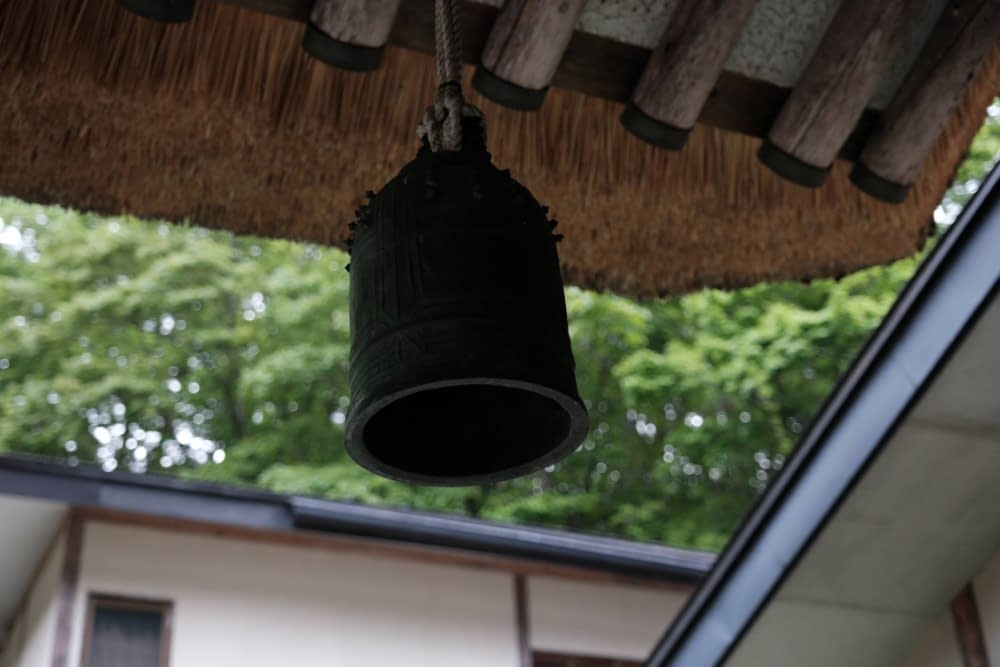 a japanese bell hanging from a traditional japanese house
