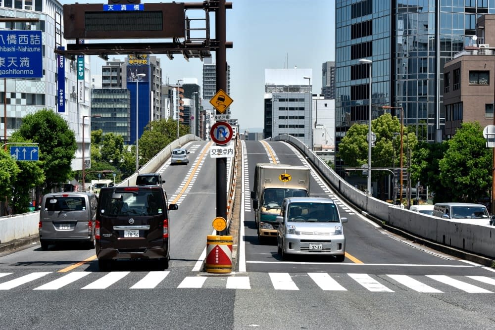 a japanese expressway with cars going up and down it