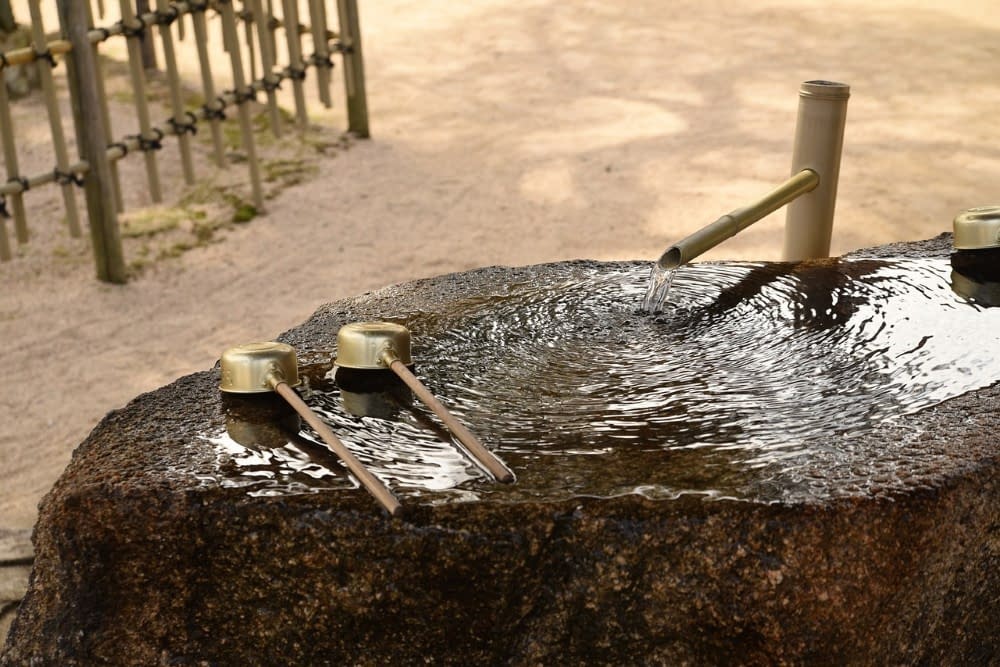 traditional japanese well made from bamboo sticks with water flowing out