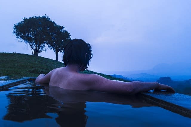 A person relaxing in an onsen on a hillside