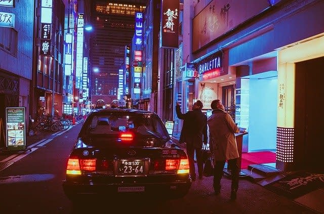 Two men getting out of a taxi in Japan.