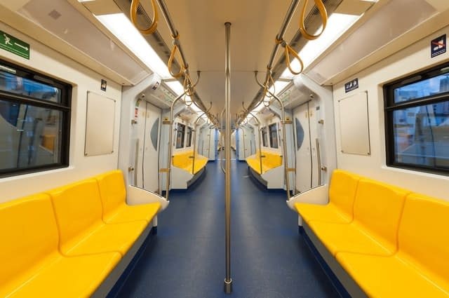 An empty subway train carriage with yellow seats