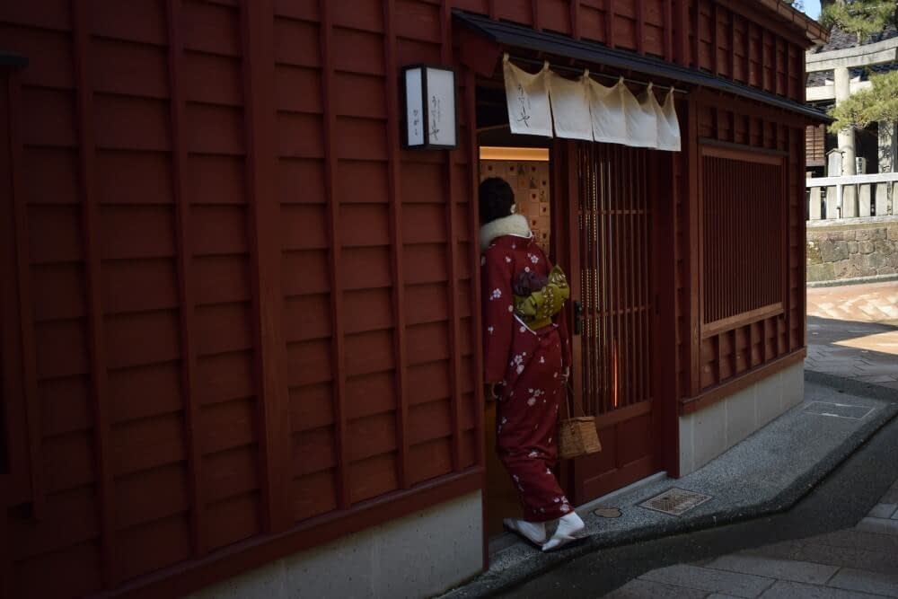 a geisha going into a teahouse