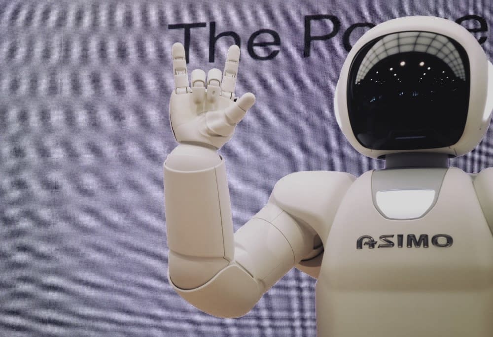ASIMO the robot holding it's hand up in a Rock and Roll sign